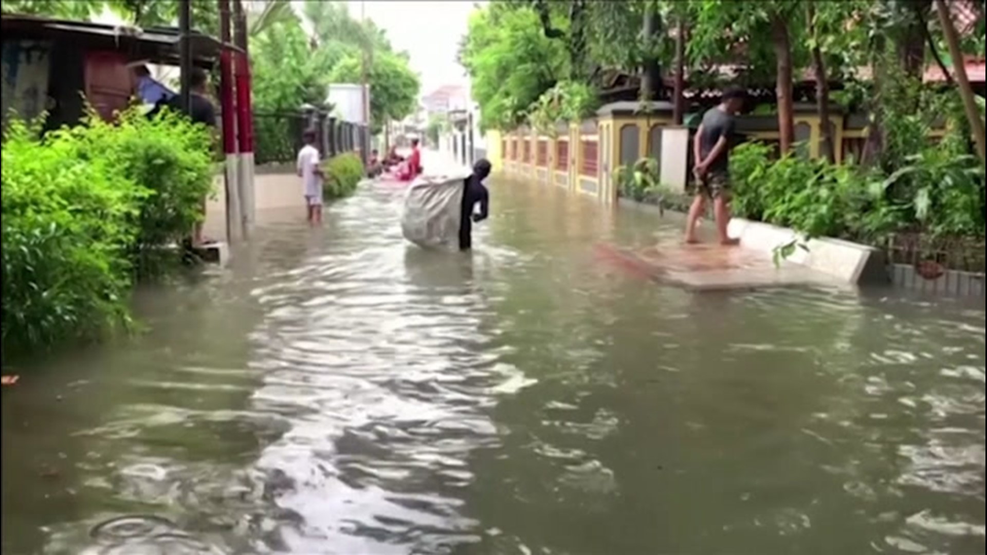 Residents of Jakarta, Indonesia, waded through flooded streets after heavy rain soaked the city on Feb. 25.