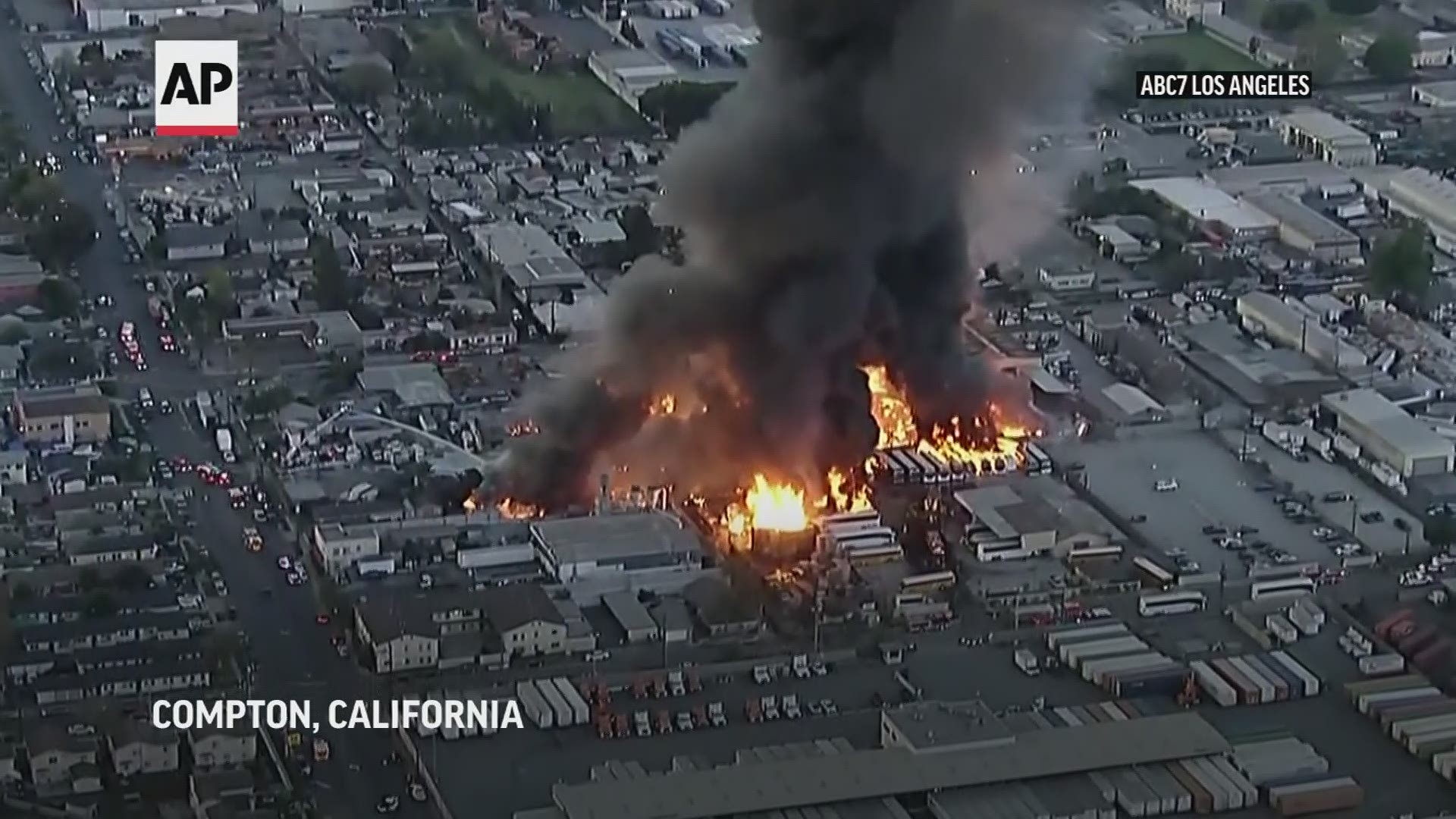 A fire erupted in Compton before dawn Friday, consuming what appears to be stacks of pallets and spreading to rows of charter-style buses.