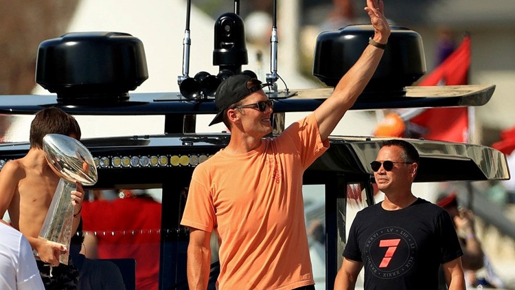 brady throws lombardi trophy to boat