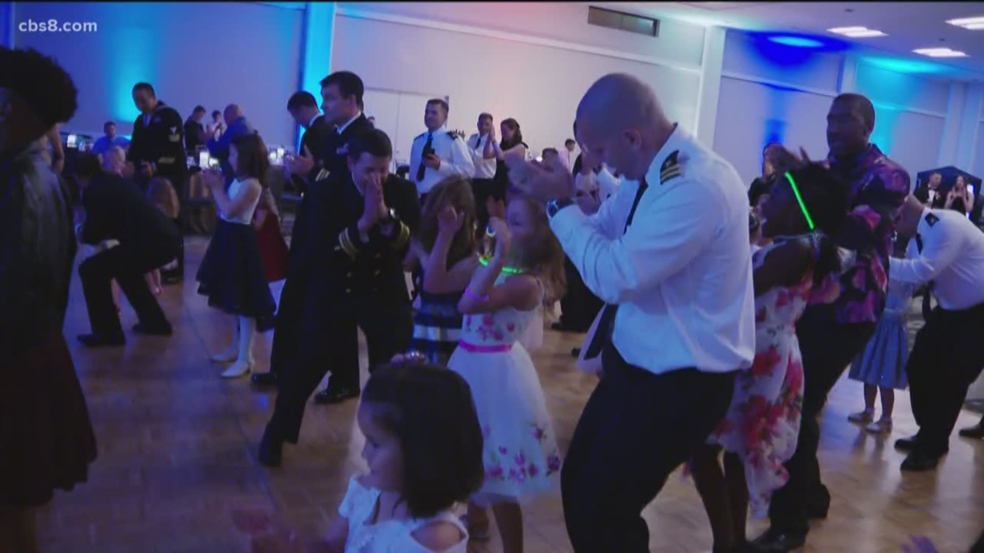 Military dad's taking their daughter for a spin on the dance floor.
