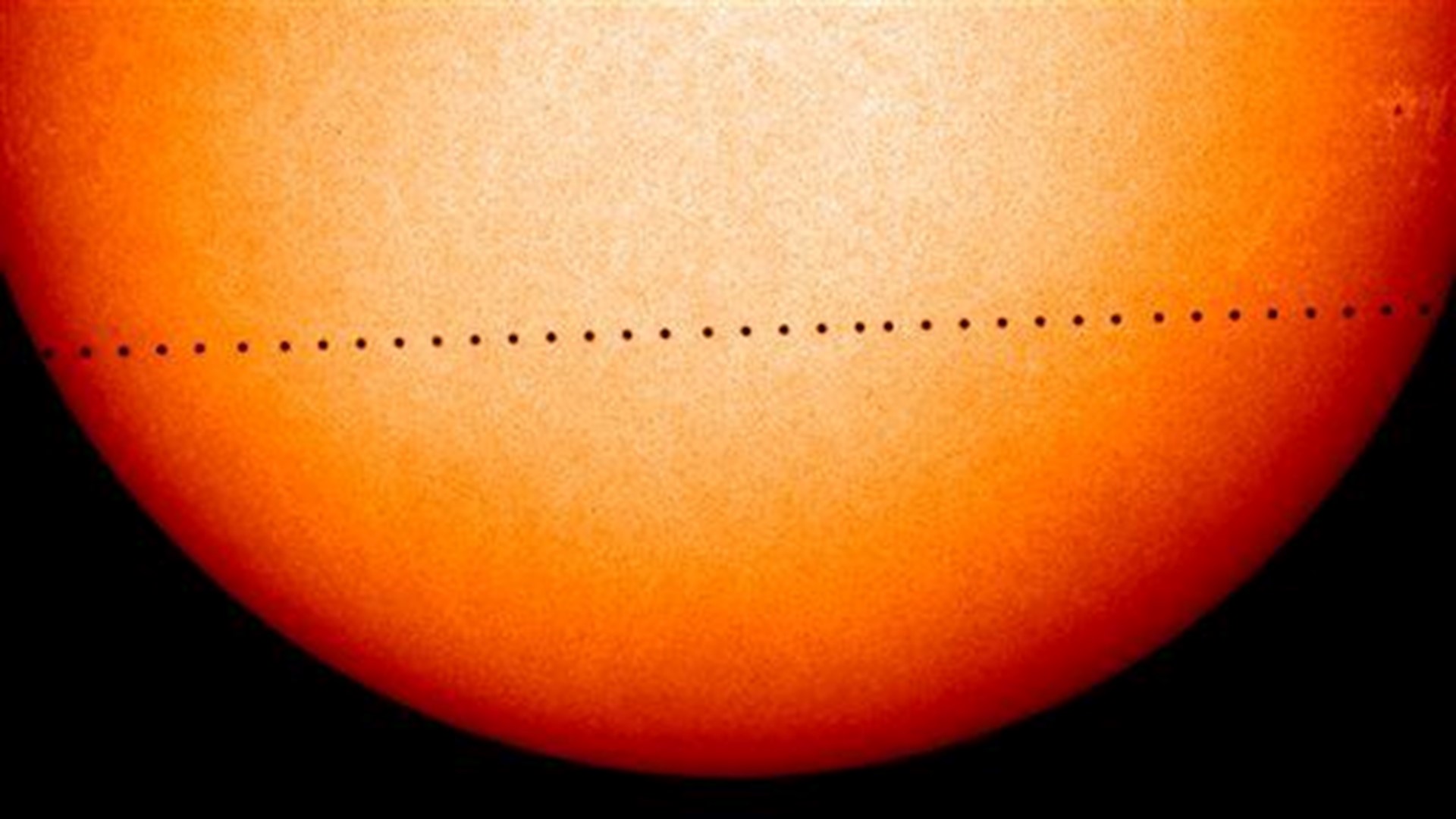 Little Mercury a black dot as it crosses vast face of sun