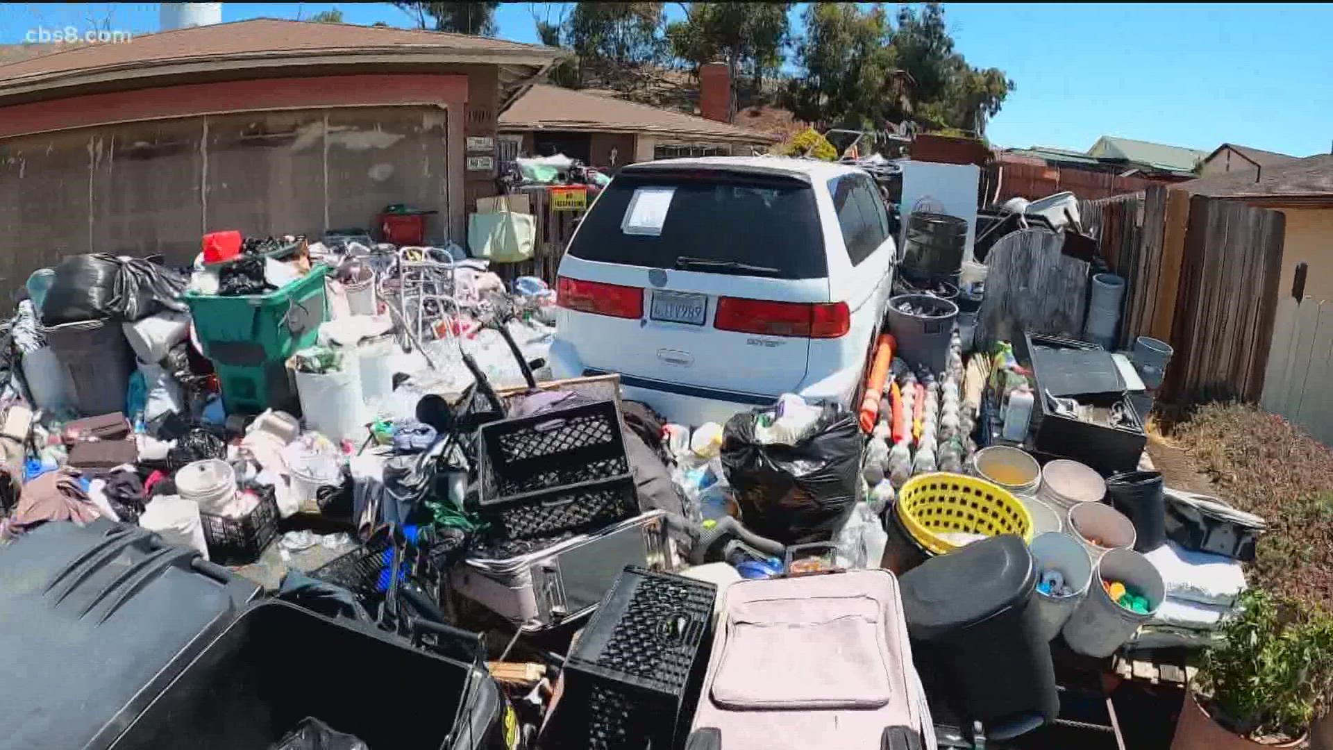 A cleanup effort is underway for a home in a Bay Terraces neighborhood piled high with trash. Neighbors complained of the stench of urine and feces for years.