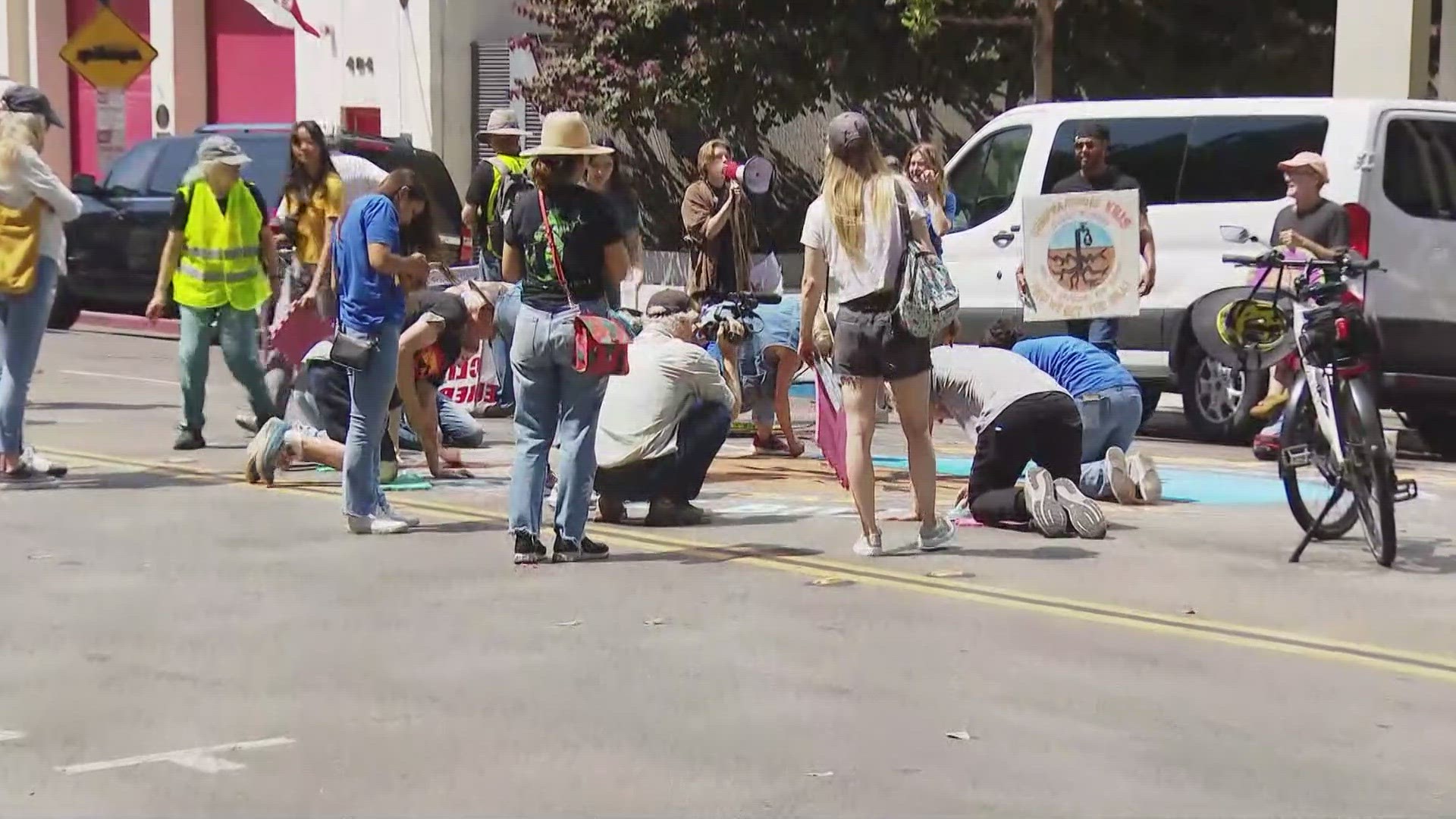 Activists blocked a portion of 8th Avenue as they created a large chalk drawing on the street, demanding Sempra stop exporting and burning fracked gas.