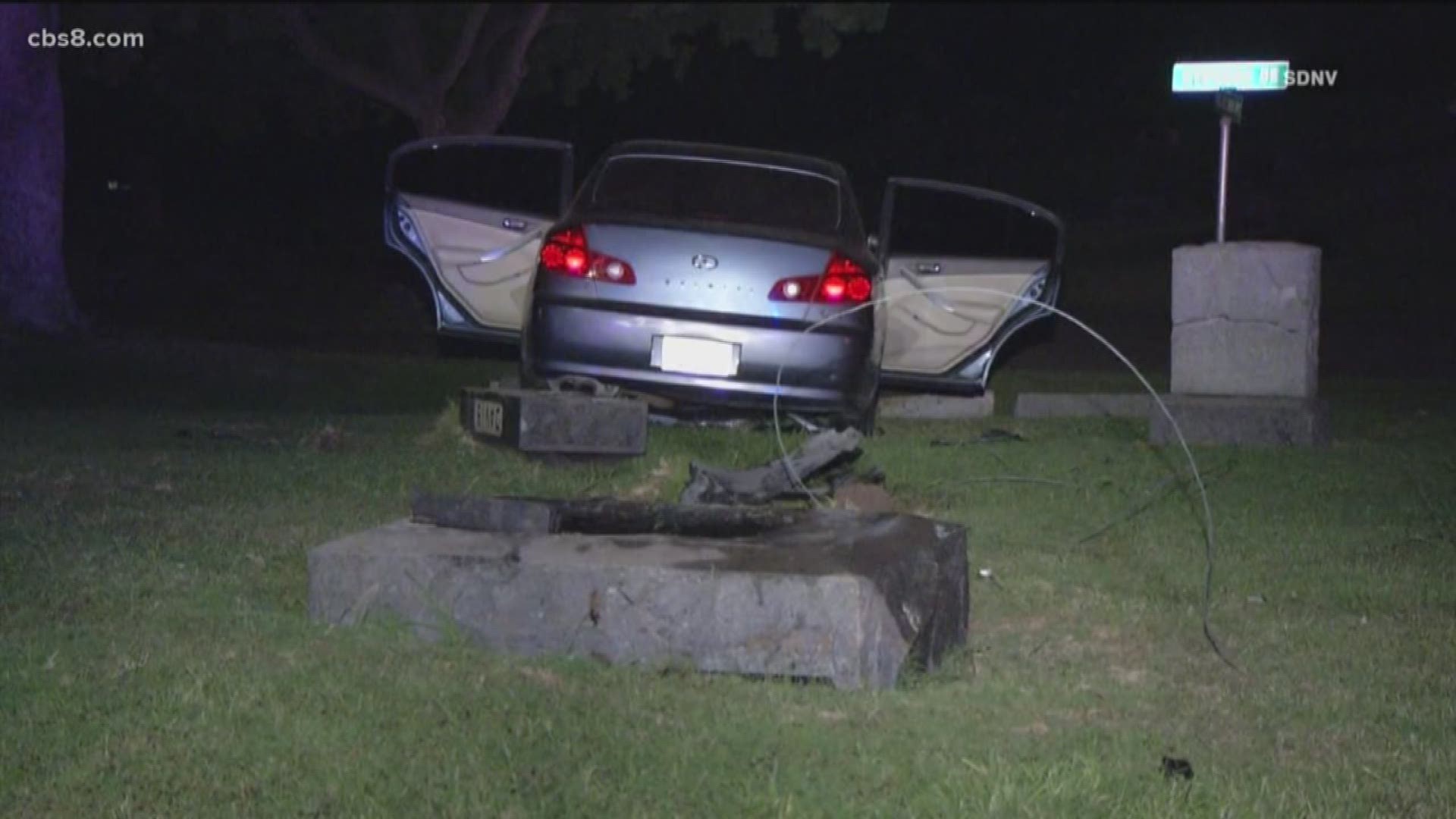 Police say a woman was grabbing onto the vehicle before the car swerved off Imperial Blvd. and crashed into the cemetery.