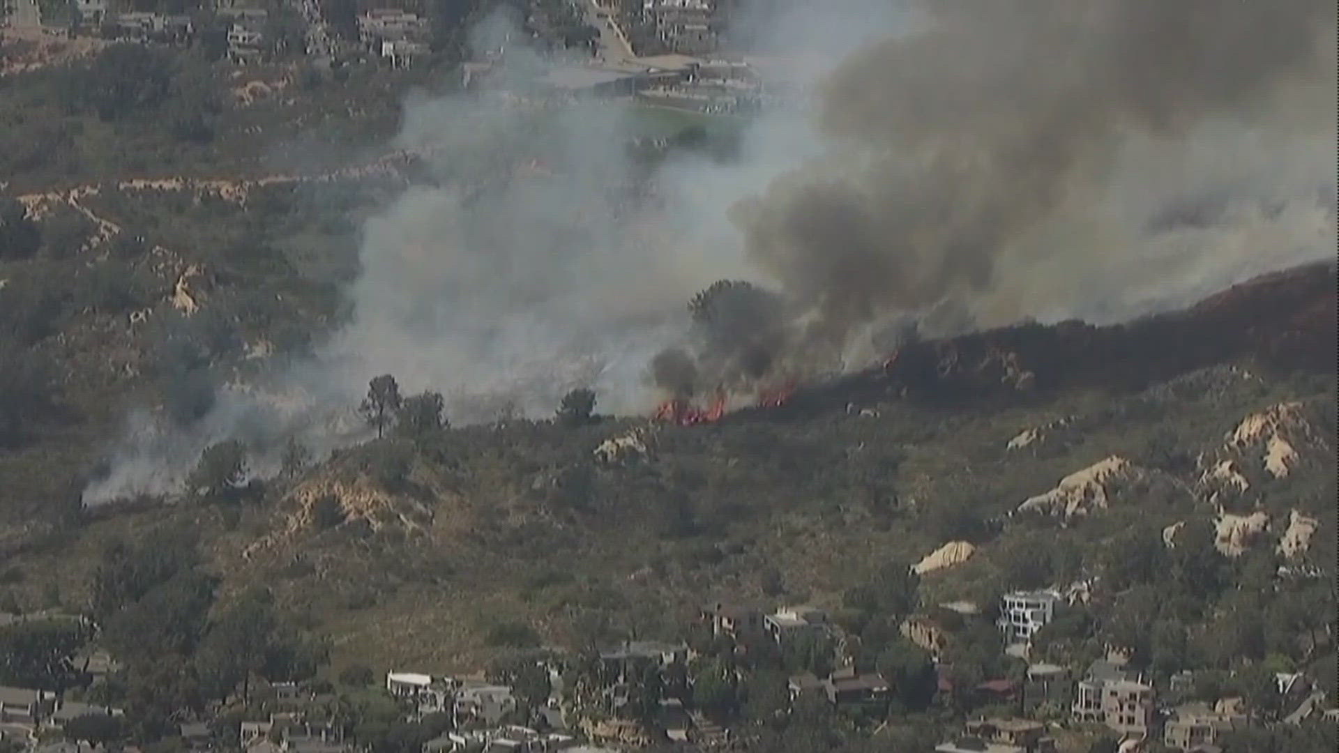 A brush fire burns near Del Mar Heights Road on Tuesday.