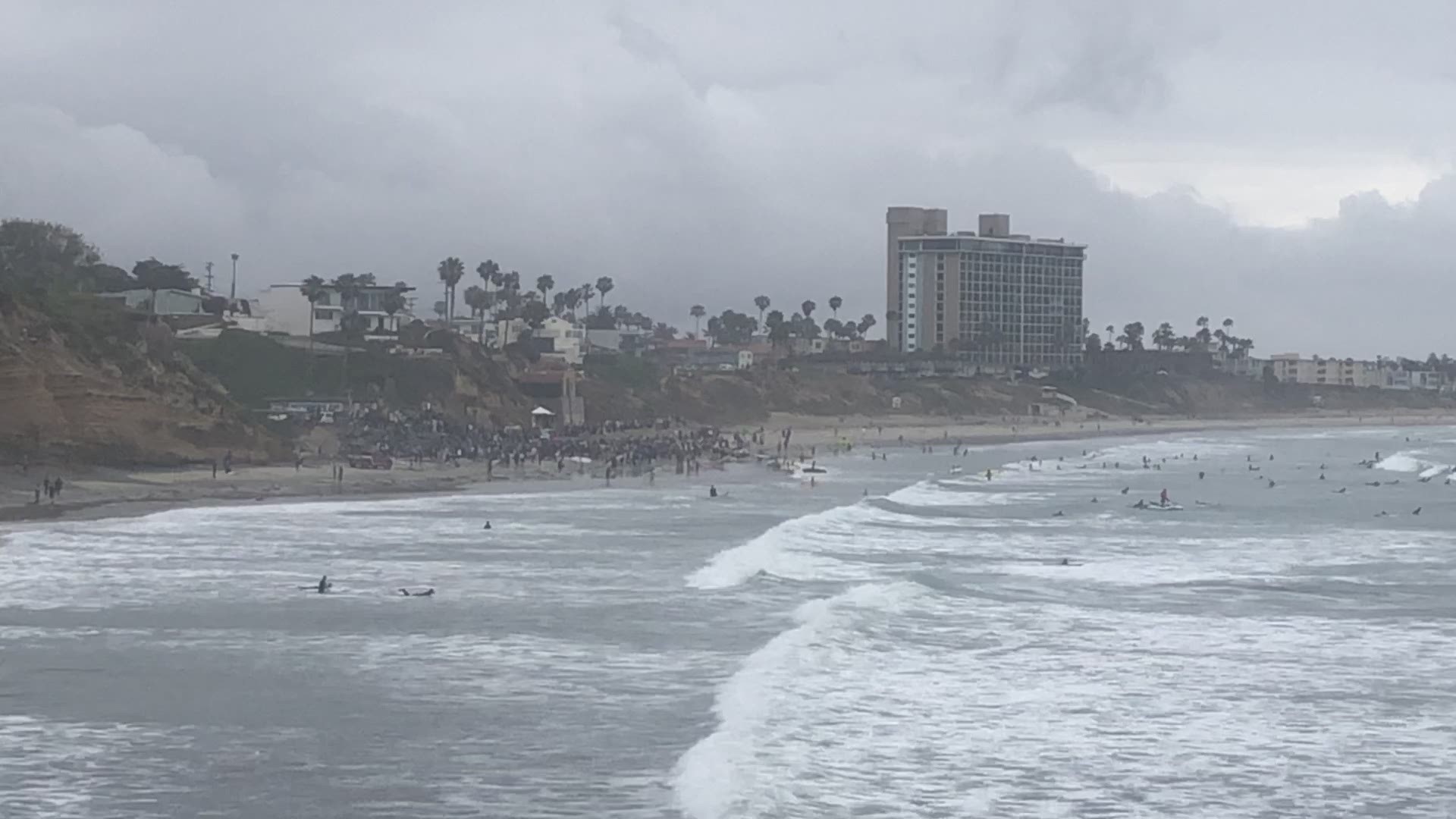 Hundreds of surfers hit the sand and water to paddle out for peace.