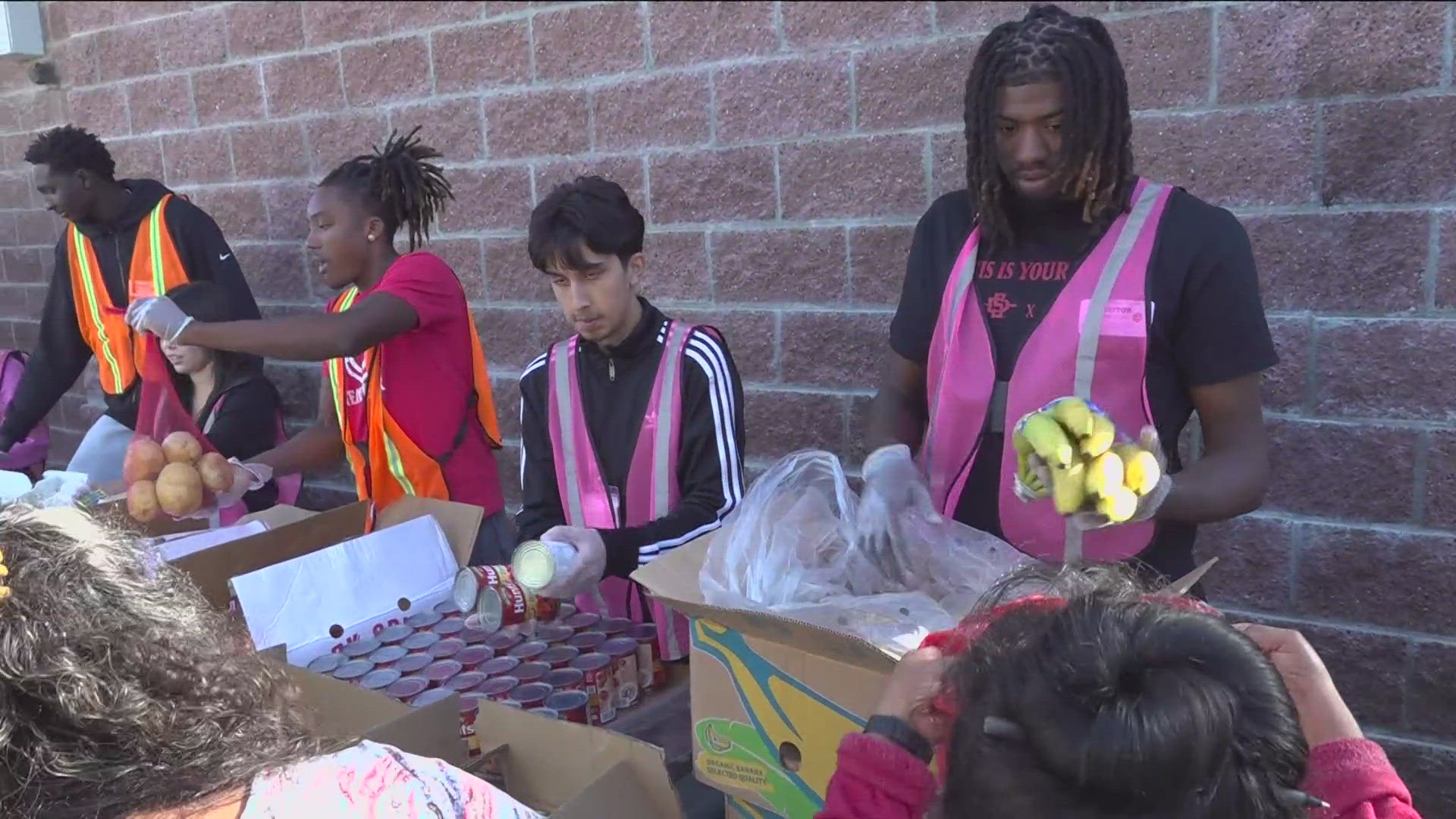 SDSU Aztecs players helped underserved Hoover High families with food donations from Feeding San Diego, aiming to expand school pantries.