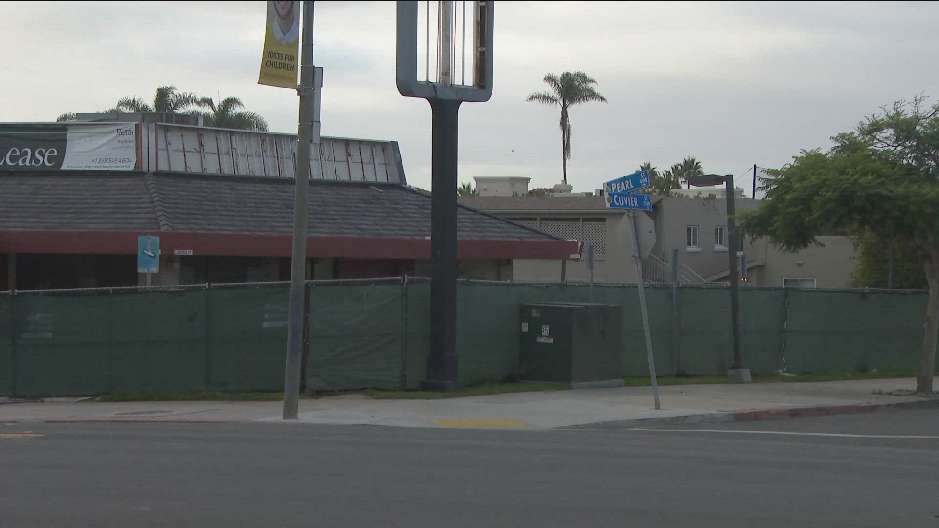 The fast food joint on the corner of Pearl and Cuvier Streets appears neglected. It's surrounded by tarp-wrapped fence and the Jack in the Box signage was removed.