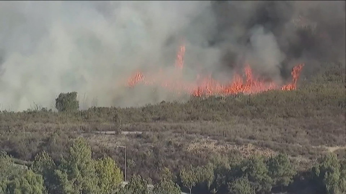 Firefighters try to put out brush fire in Poway during Red Flag Warning ...