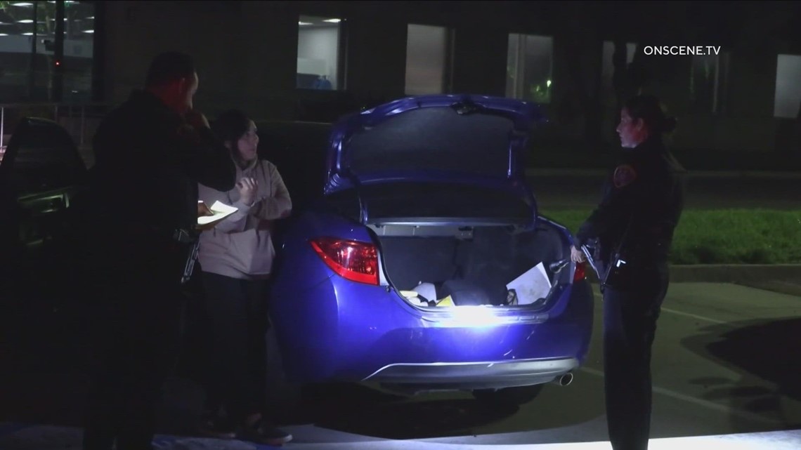 Woman surprised to find two people hiding in her trunk after crossing U